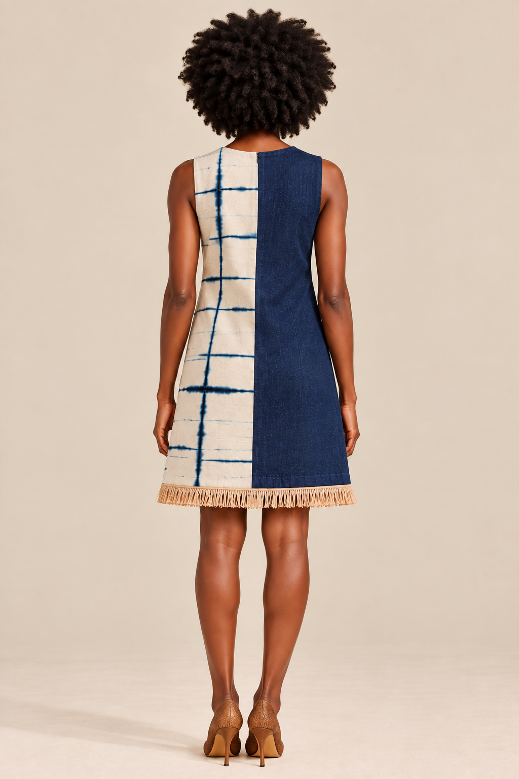 Back view of the Ola Dress showing reversed indigo denim and Kano indigo panels with natural raffia fringe at the hem.